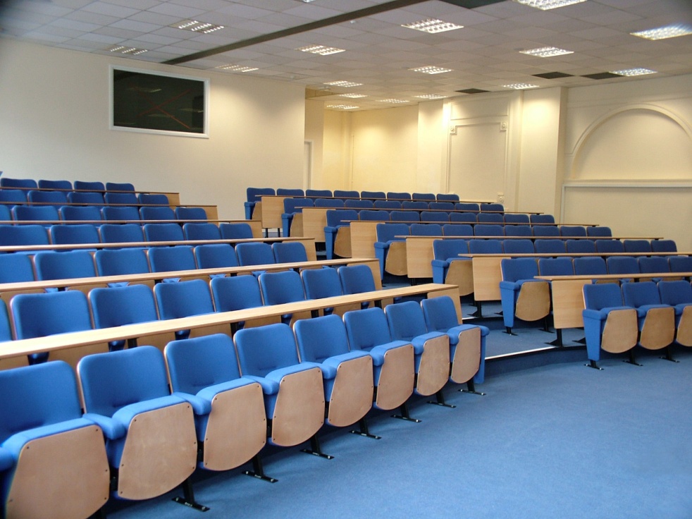 rows of lecture chairs with fixed writing desks in a university lecture theatre